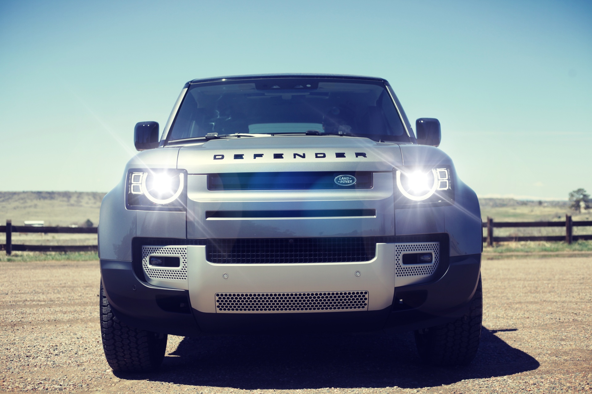 Land Rover Defender with headlamps lit, photographed head-on